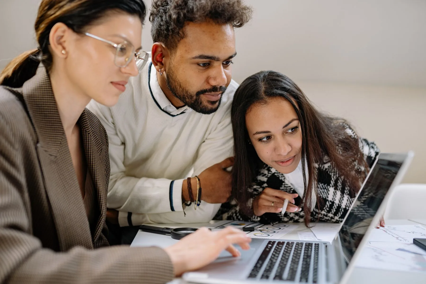 Software professionals discussing a project at a computer, a stock photograph
