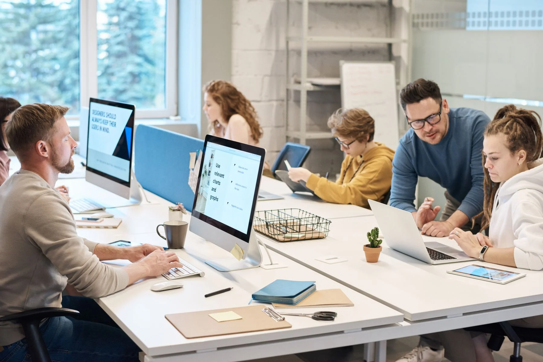 A stock photograph of people collaborating in a modern computer workspace